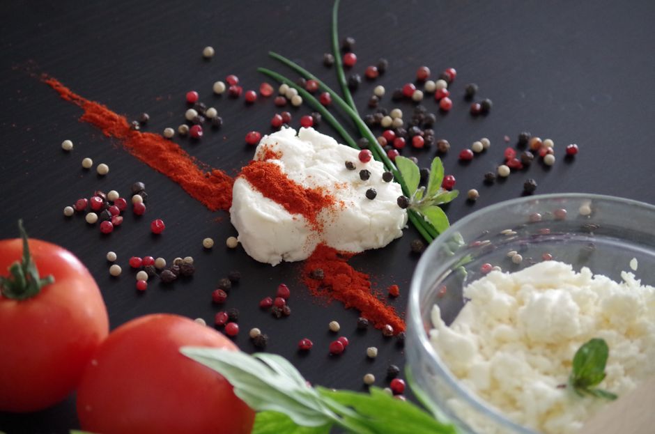 Close-up of traditional Slovak bryndza cheese garnished with herbs, spices and tomatoes, perfect for culinary stock photos.